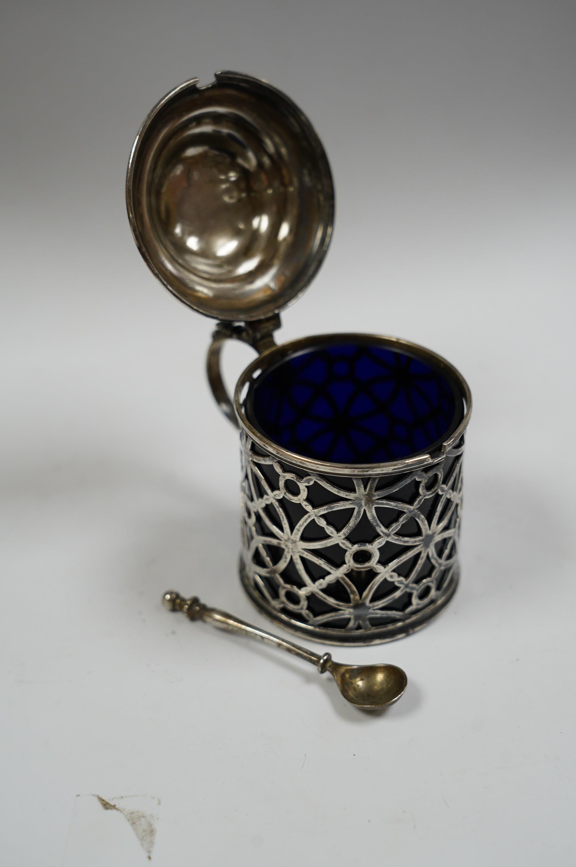 A George III pierced silver drum mustard pot, Aldridge & Green, London, 1767, height 70mm lid unmarked, with blue glass liner, later associated silver spoon. Condition - poor to fair